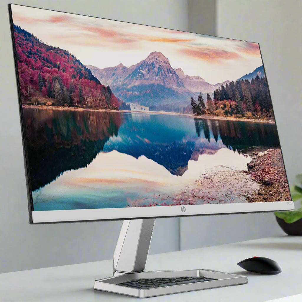 Computer monitor displaying a scenic wallpaper of a lake and mountains on a white background