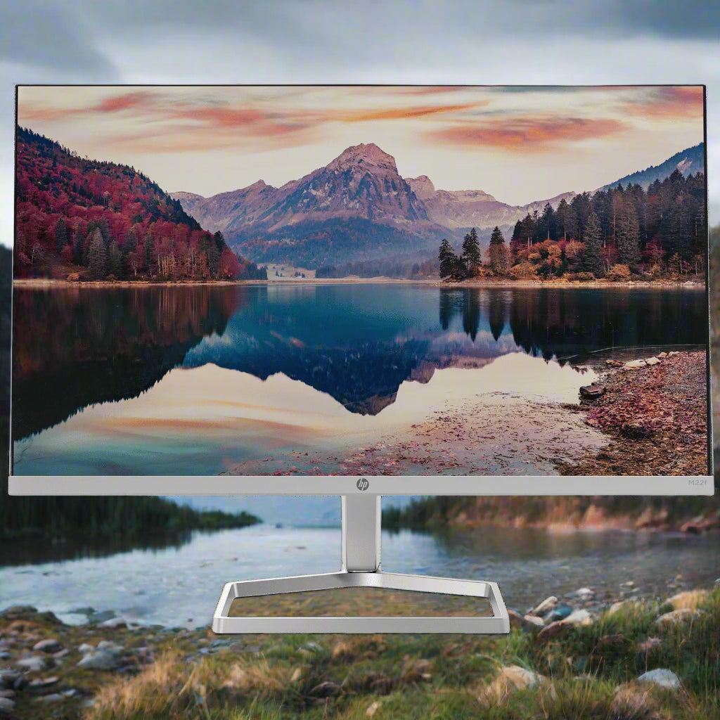 Computer monitor displaying a scenic view of a lake and mountains on a white background