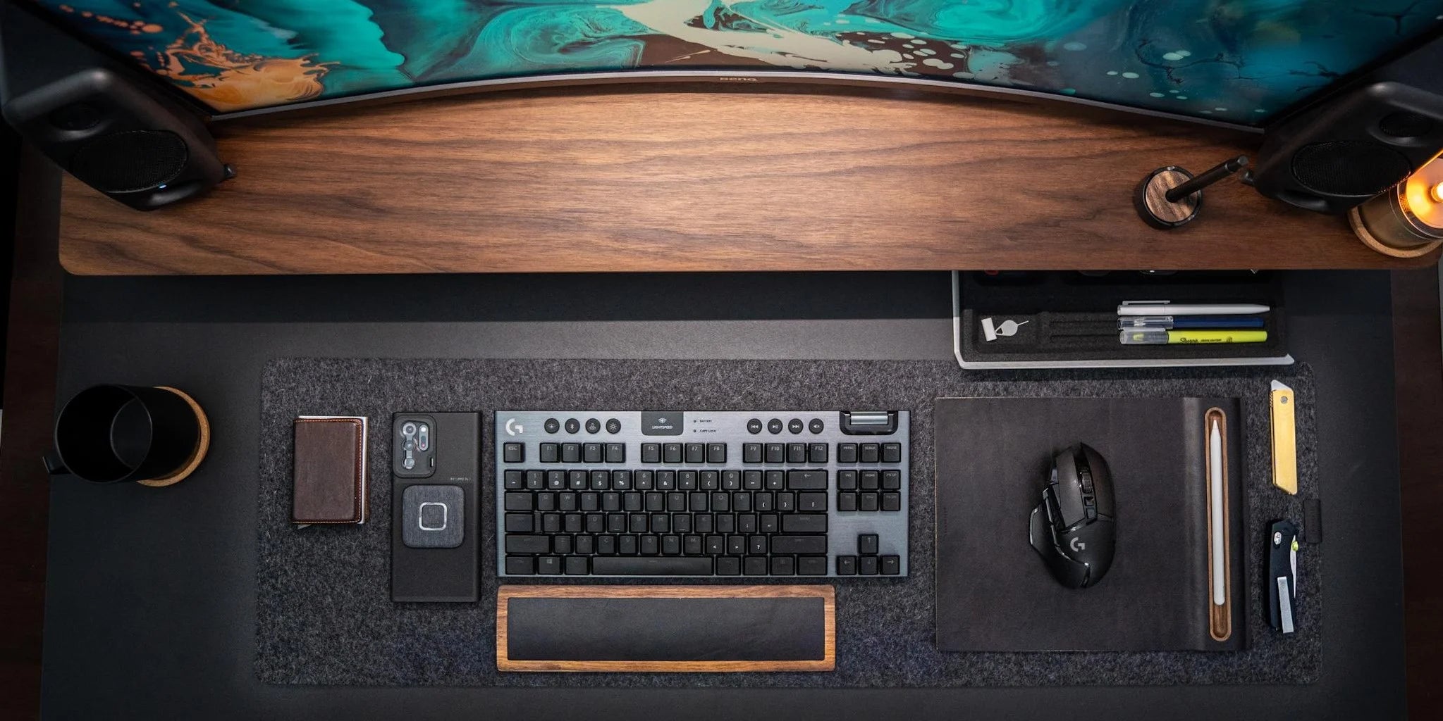 Desk setup with keyboard, mouse, and other office supplies on a wooden desk.